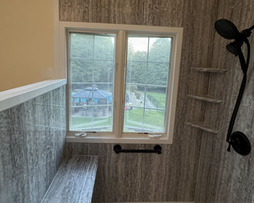 Modern bathroom vanity with dark navy cabinets, white quartz countertop, and chrome fixtures