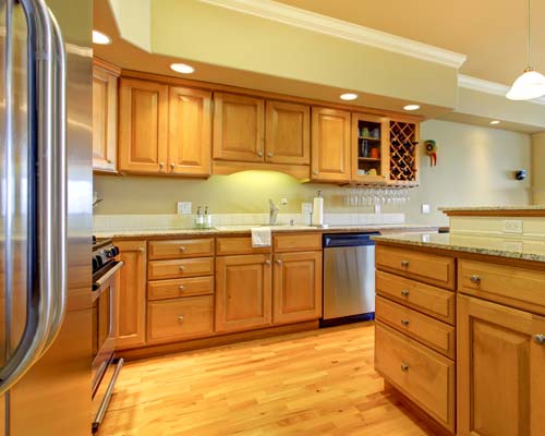 Kitchen with maple cabinetry, granite countertops, stainless appliances, and hardwood floors