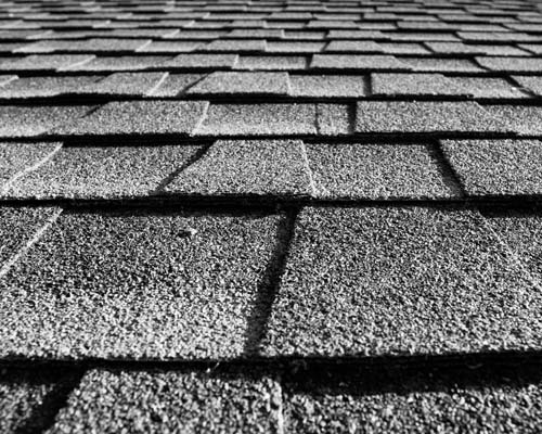 Close-up of gray asphalt shingles with textured pattern